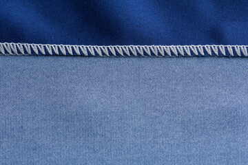 Close up of overlock seam on a blue cloth on wrong side of the fabric
