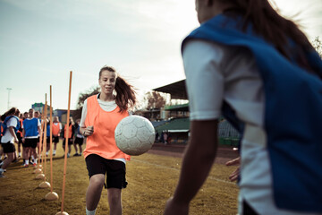 Female soccer players training with passing drills on outdoor field