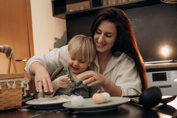 Little boy explores flour with focused hands while mom watches lovingly capturing toddler independence sensory learning bonding moments in cozy real life kitchen scene with morning tenderness