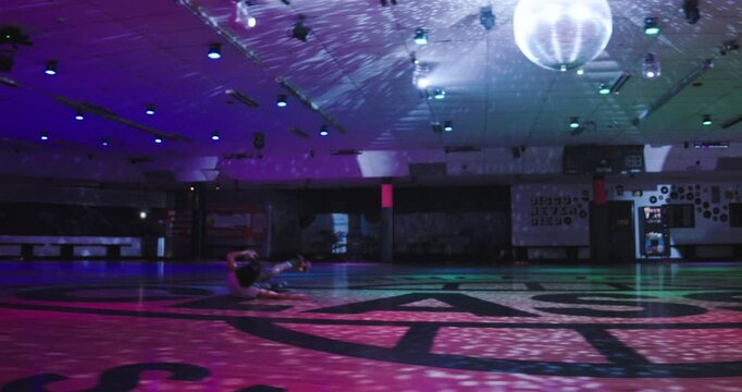Young, experienced roller skater doing epic splits trick then stumbling to floor