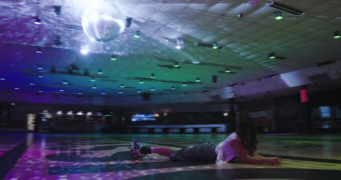 Young woman preparing to do trick on roller skates then splatting on ground and making cute pose - steady cam shot