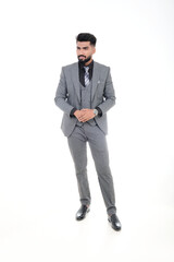 A man in an elegant gray suit with a tie and watch, a stylish business look on a white background.