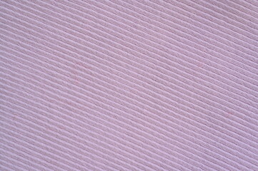 pink texture of knitted synthetic fabric as a background, pink smooth symmetrical lines of synthetic fabric