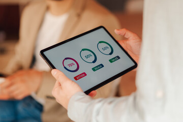 Marketing manager showing kpi data on tablet to client during meeting