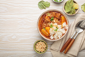 Aromatic massaman curry, a staple of thai cuisine, with tender beef, potatoes, and fluffy rice,...