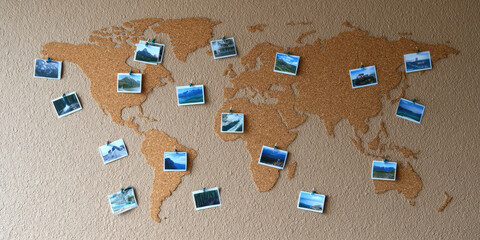A cork world map is adorned with various landscape photos pinned at different locations. Concept: Travel memories and exploration