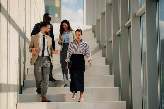 Business people walking down stairs in modern office building