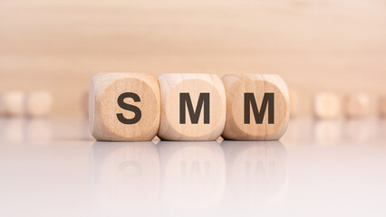Wooden blocks with letters SMM on light background, social media marketing concept.