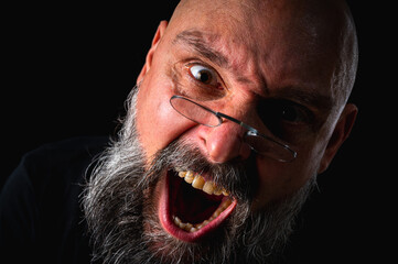 Funny close-up portrait of a quirky bald man with a long gray beard and eyeglasses, making a silly face. Concept of eccentricity, humor, and expressive personality.