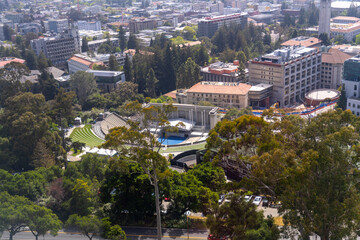 Obraz premium Aerial view of Berkeley's Greek Theatre, surrounded by trees and buildings, on a sunny day.
