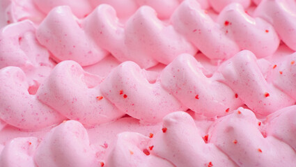  Extreme close-up macro shot of creamy pink strawberry ice cream or frosting with beautifully piped soft swirls and tiny red flecks or sprinkles under bright soft light.