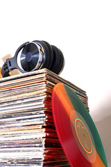 Headphones lying on a stack of vinyl records. Concept of analog sound lovers.