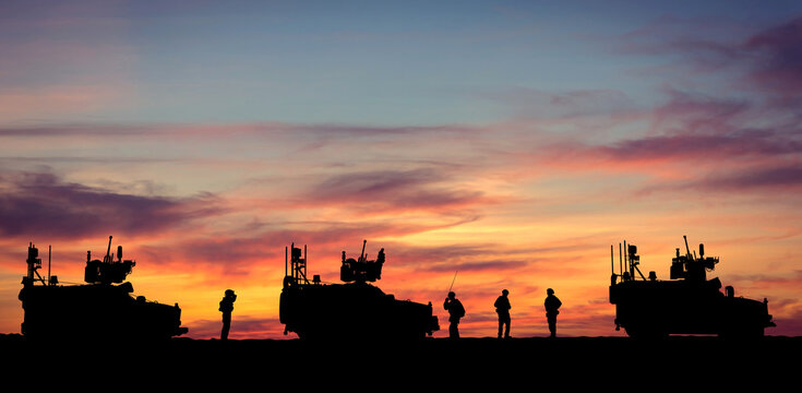 Silhouettes of military armored vehicles and soldiers standing at sunset. Tactical operation or border patrols. Suitable for design on theme, air defense, army operations, security, technology in war.