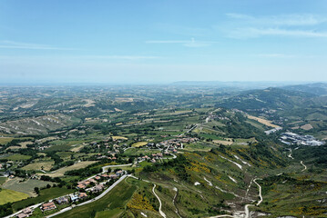 Obraz premium Aerial view of a vast city with sprawling land and trees in San Marino
