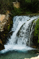 Obraz premium Clear waterfall water flows over rocky ledge. Image suitable for nature, travel, or relaxation context and purpose.