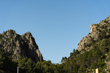 Natural mountain landscape with rocky cliffs and green trees. Useful for nature, travel, or outdoor adventure themes.