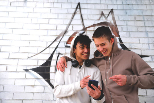 One latinamerican teenager showing on smartphone to causacian boy, technology