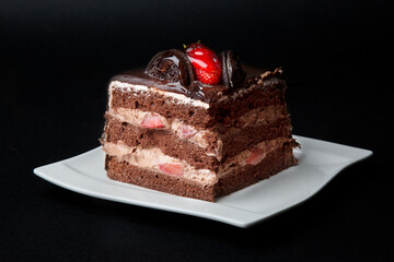 Triangle shape slice piece of chocolate fudge cake decorated with chocolate