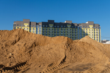 Construction of a multi-storey building with a crane against the blue sky.