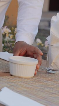 Close-up of a waiter carefully arranging cutlery on a beautifully set dining table. Elegant table setting, refined hospitality, and attention to detail create a premium restaurant atmosphere.