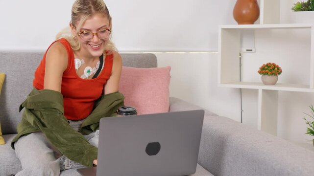 Young woman wearing holter monitor using laptop at home