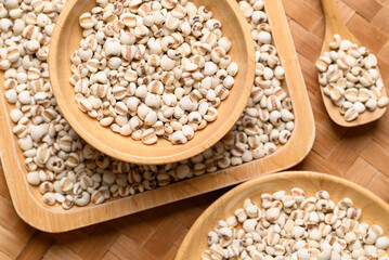 Dried Job's tears or adlay millet seeds in wooden bowl with spoon, Food ingredient, Top view