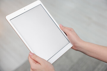 Woman with modern tablet at home, closeup