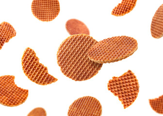Yummy Dutch waffles (stroopwafels) flying on white background