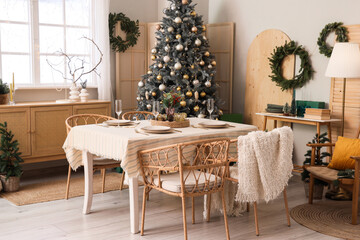 Interior of dining room with table, Christmas tree and wreaths