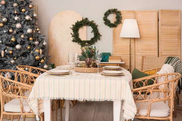 Interior of dining room with table, Christmas tree and wreaths