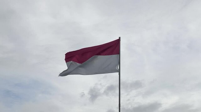 Indonesian Flag Flying on Pole with Cloudy Atmosphere