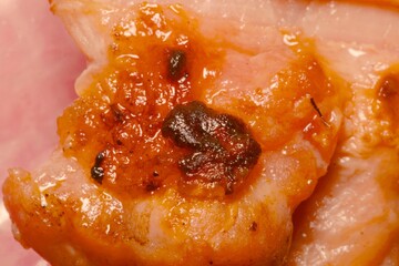 Barbecued pork with areas of heavy charring, associated with traditional grilling and awareness of cooking-related carcinogens.