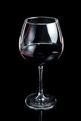 The glass of red wine on a black background