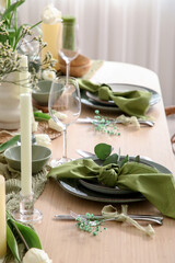 Elegant table setting with beautiful flowers and folded napkins in restaurant, closeup