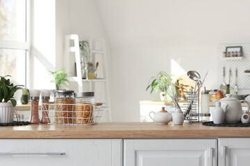 Different utensils with jars of pasta on counter in kitchen