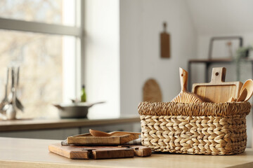 Basket with cutting boards on table in kitchen