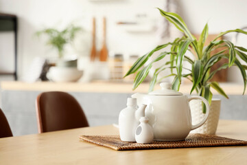 Ceramic set with plant on dining table in kitchen, closeup