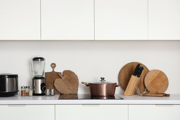 Utensils with appliances on counters in kitchen