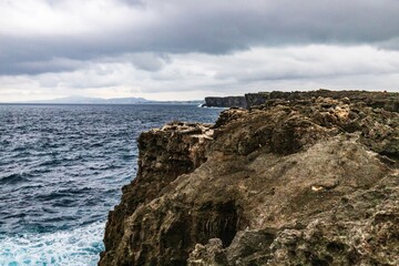 Stormy CoasStormy Coastal Cliffs with Crashing Waves Under Dark Skytal Cliffs with Crashing Waves Under Dark Sky