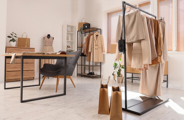 Interior of stylist's studio with clothes racks and workplace