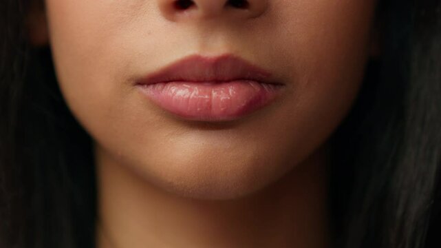 Extreme close up mouth woman lips Hispanic ethnic girl teen teenager Latina female plump lip beauty procedure makeup lipstick cosmetic injection filler plastic surgery cosmetology face cropped view