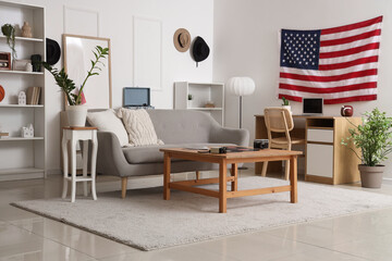 Interior of living room with USA flag, sofa and workplace