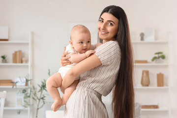 Happy mother holding her little baby at home