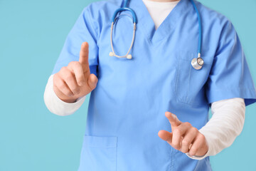 Male doctor using virtual screen on blue background, closeup