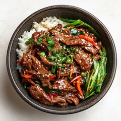 Overhead View of a Dark Bowl of Beef Stir Fry with Brown Rice and Vegetables