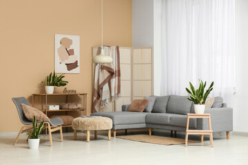 Sofa, chair, pouf and sansevieria plants in interior of living room
