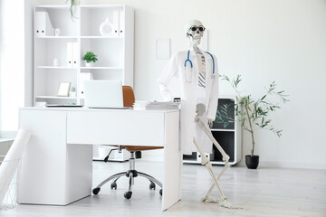 Human skeleton model with doctor's coat in medical office