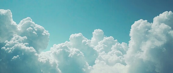 Fluffy white cumulus clouds against a vibrant teal blue sky