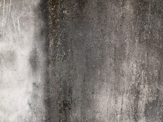 Weathered texture of an old concrete wall, displaying a mottled pattern of stains and...