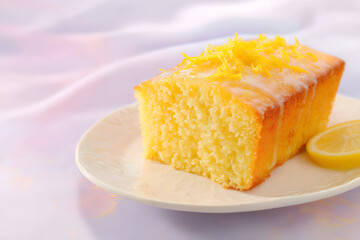 Zesty lemon drizzle cake with soft, airy lemon sponge that captures the essence of citrus and is topped with a tangy sweet glaze. Food concept